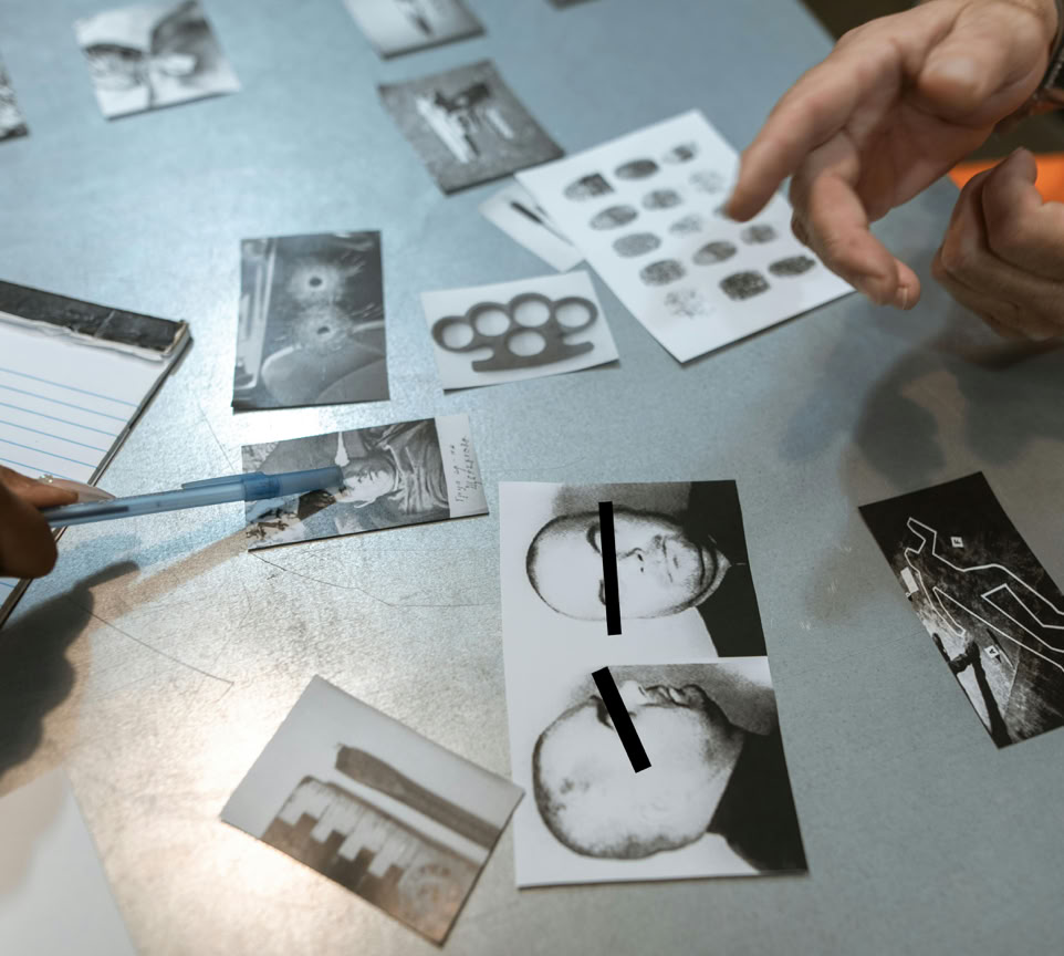 Investigation scene with evidence photos discussed. Officers analyze suspect details.